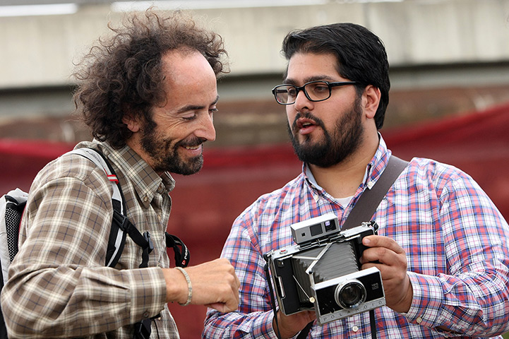 Hipster Olympics: An attendee shows another his Polaroid Land Camera 