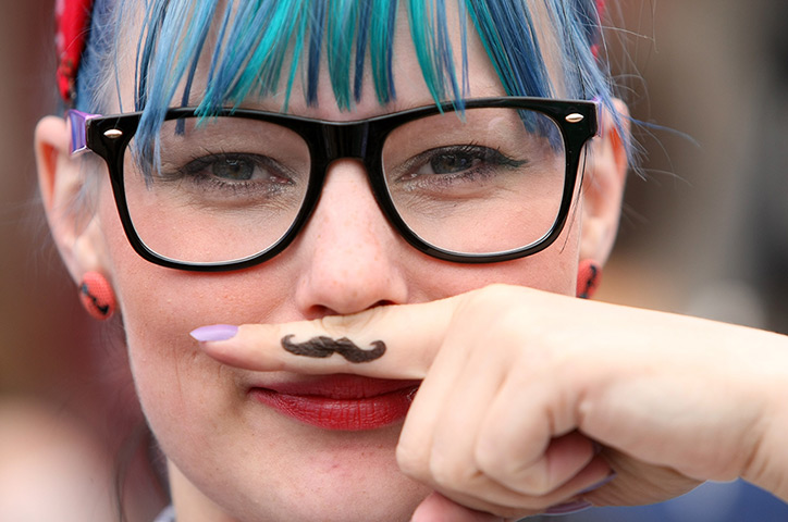Hipster Olympics: A visitor uses her finger as an ironic Hipster moustache 