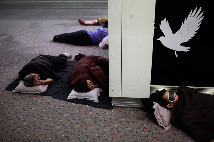 24 hours in pictures: Passengers sleep on the ground after Typhoon Vicente stranded flight