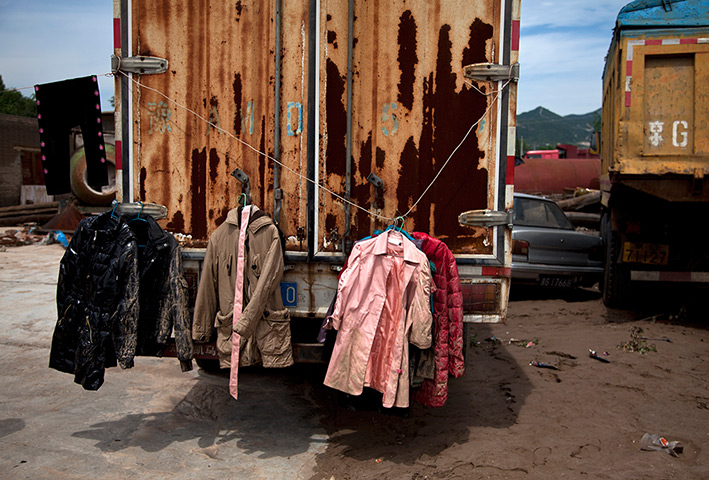 24 hours in pictures: Muddy clothes are hanged on a truck damaged by flood, China