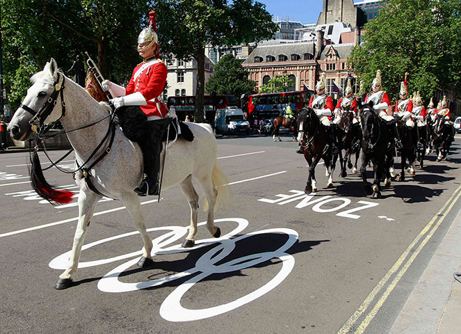 Picture desk live: Members of the Household Cavalry ride down an Olympic Lane in London