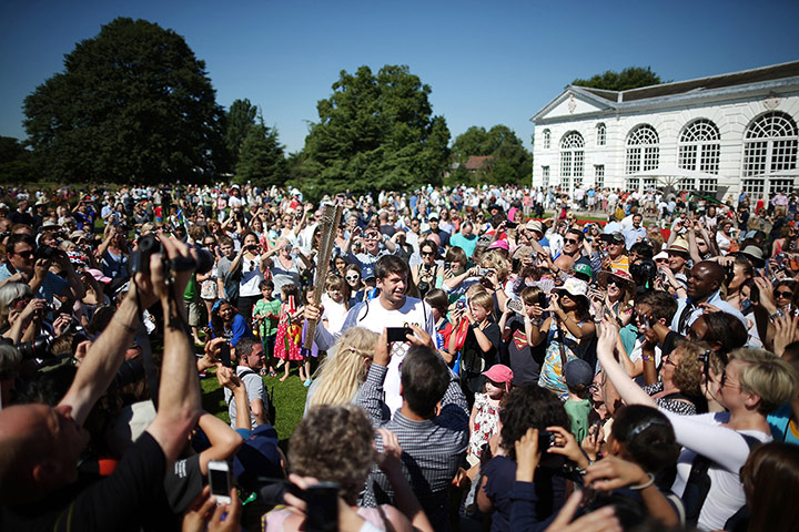 Picture desk live: The crowd mob tennis player Oli Golding with the Olympic torch at Kew