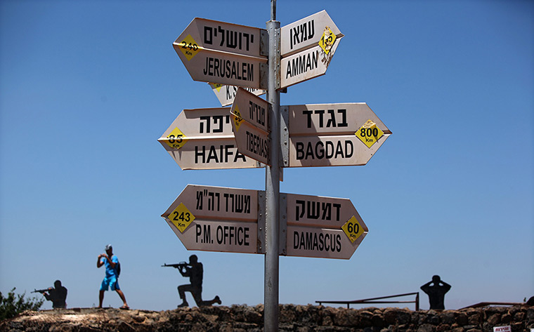 24 hours: Golan Heights: A tourist takes a picture near a signpost