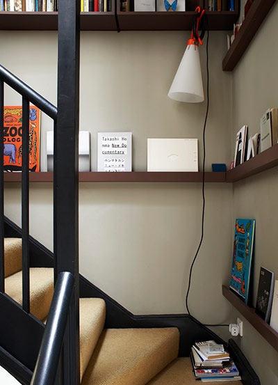 Homes - Narrow house: Shallow bookshelves, designed to store books face-on, line the stairway