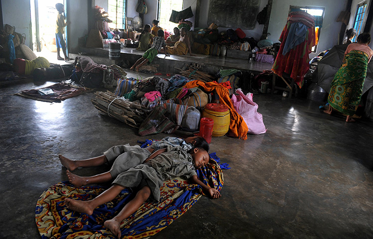 24 hours: Gosaigaon, India: Displaced Bodo villagers rest in a village
