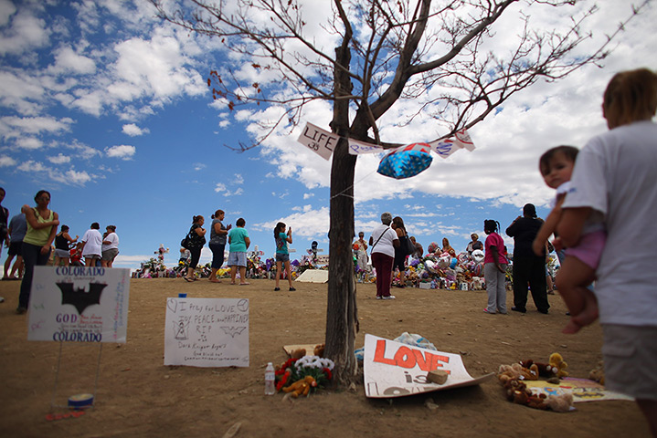 24 hours: Aurora, Colorado, USA:  People visit a makeshift memorial 