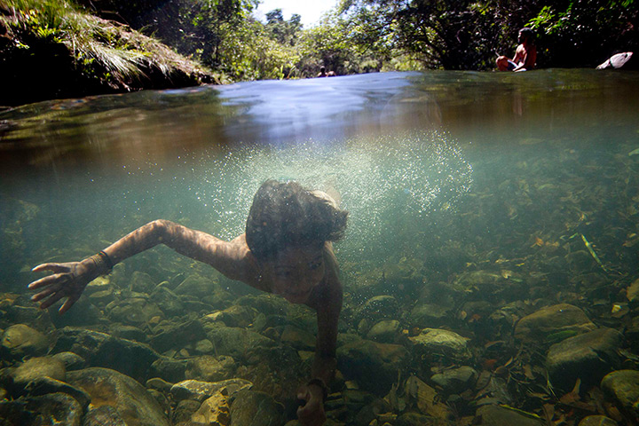 24 hours: Goias, Brazil: An indigenous child swims in the Sao Miguel river