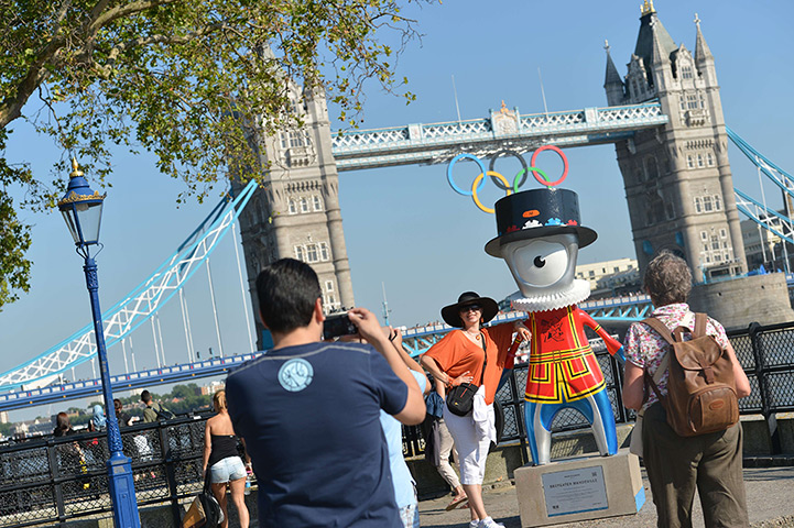Olympic week build up: People take photos with Olympic mascot by the Thames near Tower Bridge