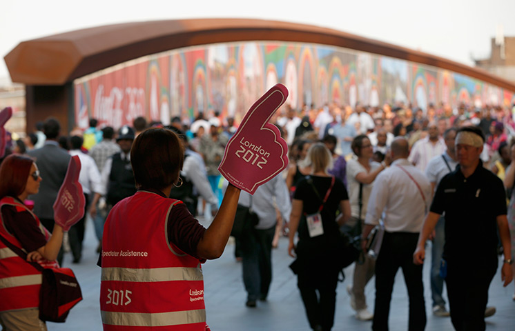 Olympic week build up: Workers direct crowds of people as they make their way to Olympic Stadium 