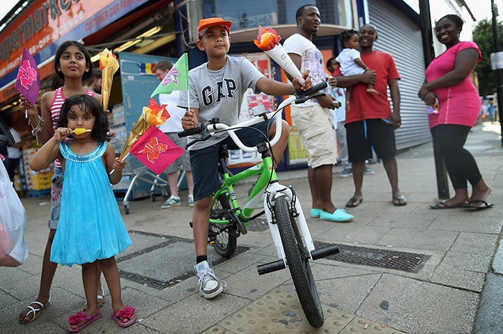 Olympic week build up: Members of the public gather to watch Torchbearer along Tottenham High Road