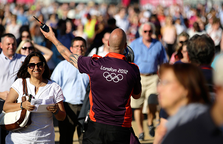 Olympic week build up: A man directs the crowd at the Olympic Park in Stratford