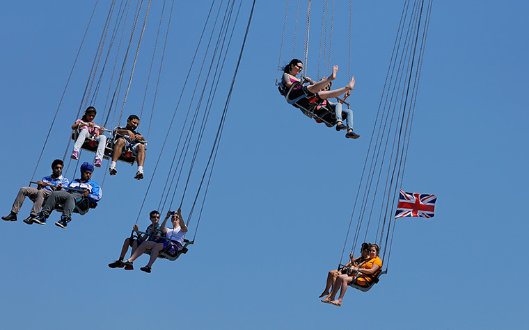 Olympic week build up: People ride a large carousel on the south bank of the river Thames