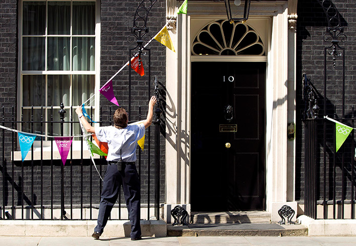 Olympic week update: A worker fixes Olympic bunting to Downing Street
