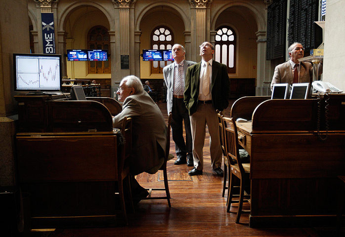Week in Business: Traders look at electronic boards at the stock exchange in Madrid