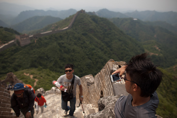 Week in Business: A tourist takes photos using an iPhone at the Great Wall of China