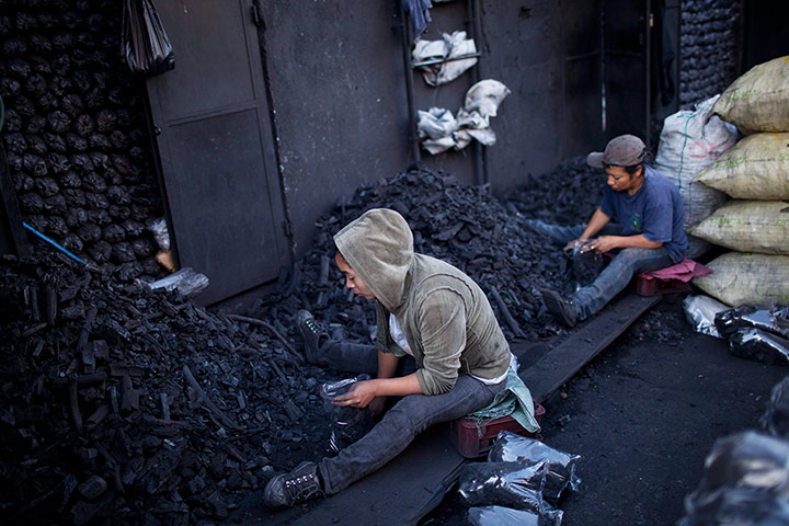 24 hours: Women cull through piles of charcoal pieces