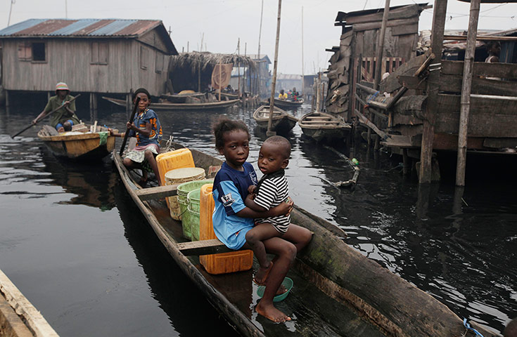 24 hours: A woman paddles a canoe past stilt houses at Makoko