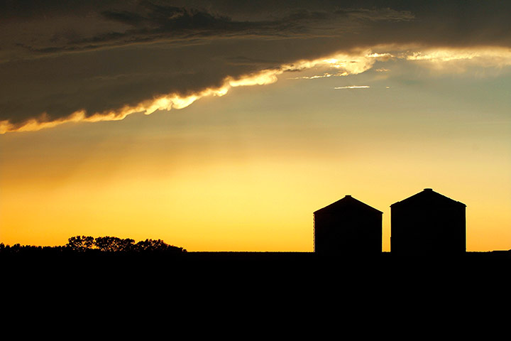 24 hours: Grain bins are silhouetted against approaching storm clouds