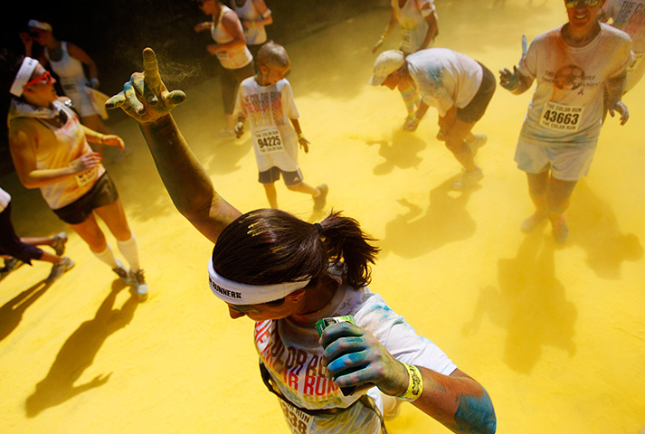 24 hours in pictures: Runner holds up colored finger during the Color Run in Amesbury
