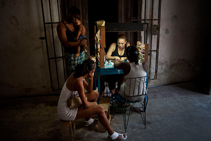 24 hours: Havana, Cuba: A young woman has her manicure done at a private manicure stand 