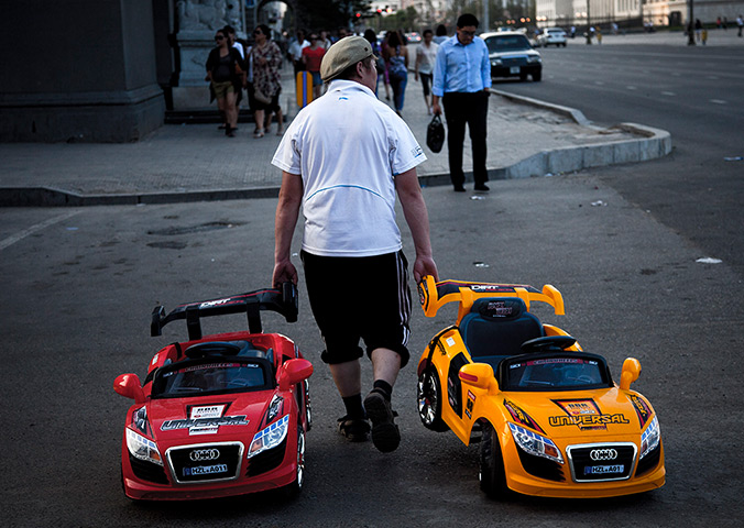24 hours: Ulan Bator, Mongolia: A Mongolian vendor pulls along toy cars 