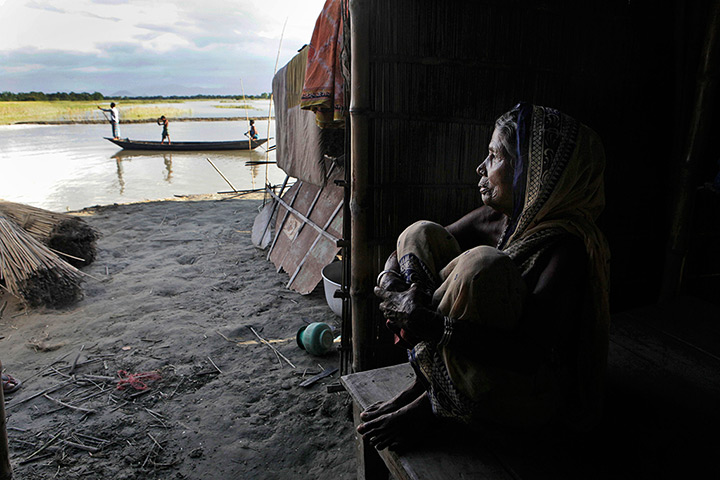 24 hours: Gagalmari, India: A woman sits in a makeshift temporary hut after floods