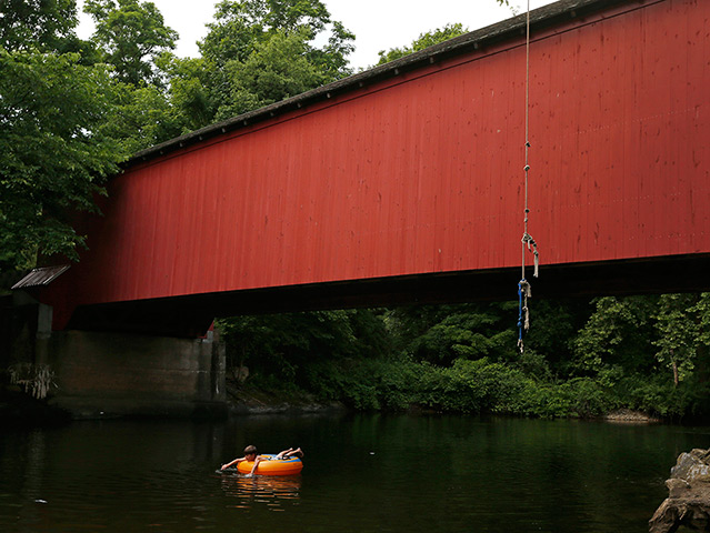 24 hours: Jackson, New York, US: A boy floats on an inner tube 