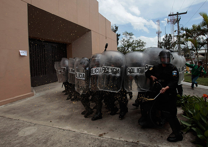 24 hours: Guatemala City, Guatamala: A riot police officer sprays pepper at a protest