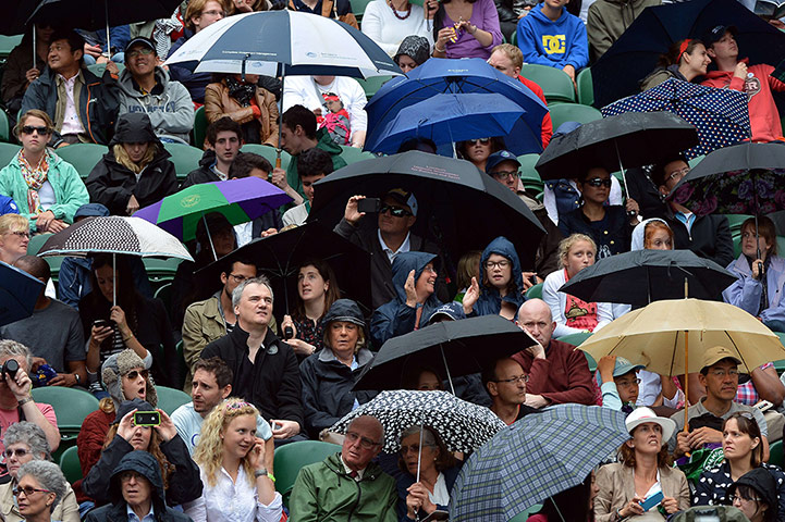 Picture desk live: Spectators on Centre Court at Wimbledon shelter from the rain
