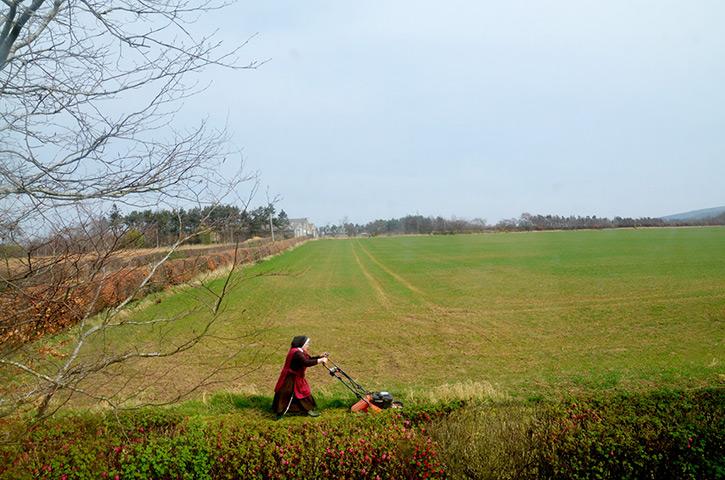 Foto8 Summershow : Nun cutting the grass. East Lothian, Scotland