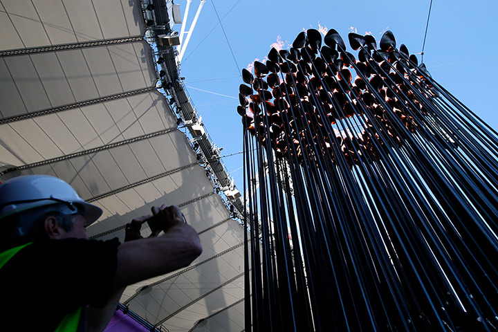 Olympic cauldron: A worker photographs the Olympic cauldron after it was moved