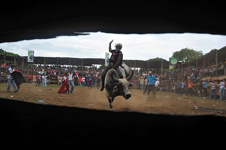 24 hours: Managua, Nicaragua: A man rides a bull at San Roque Rodeo
