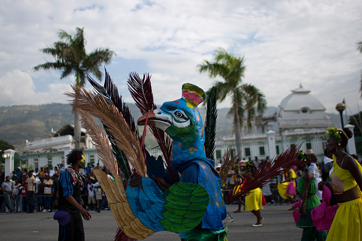 24 hours: Port-au-Prince, Haiti: A man wears a peacock mask at a parade