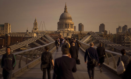 Workers make their way across Millennium Bridge into the City of London