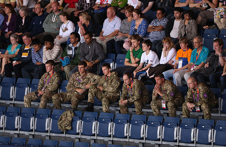 Olympic empty seats : Army personnel sit in the empty seats at the badminton at Wembley Arena