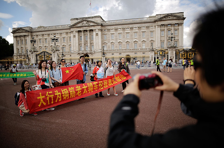 Quiet London: Chinese tourists have their pictures taken outside Buckingham Palace