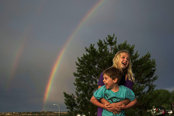Picture desk live: Children play in front of a rainbow after a heavy rain in Colorado Springs