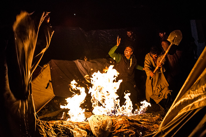 FTA: Daniel Berehulak: Men put out a fire, after some kerosene spilled onto a tent, at a campsite 