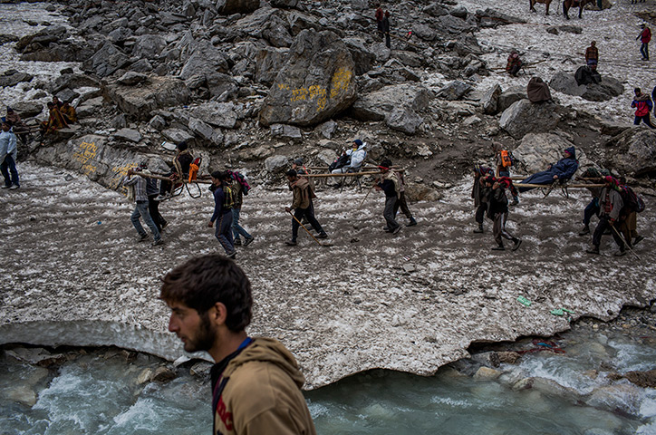 FTA: Daniel Berehulak: Hindu pilgrims are carried on palanquins by Kashmiri bearers over a glacier
