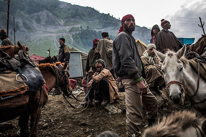 24 hours in pictures: A Kashmiri guide yawns as he and others wait with their horses