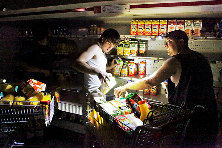 24 hours in pictures: Men fill their shopping cart after storm hit Virginia
