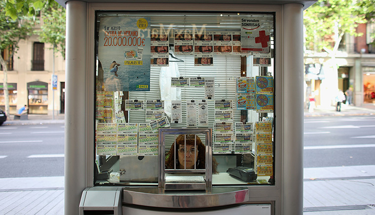 24 hours: Madrid, Spain: A woman sells lottery tickets from a booth 