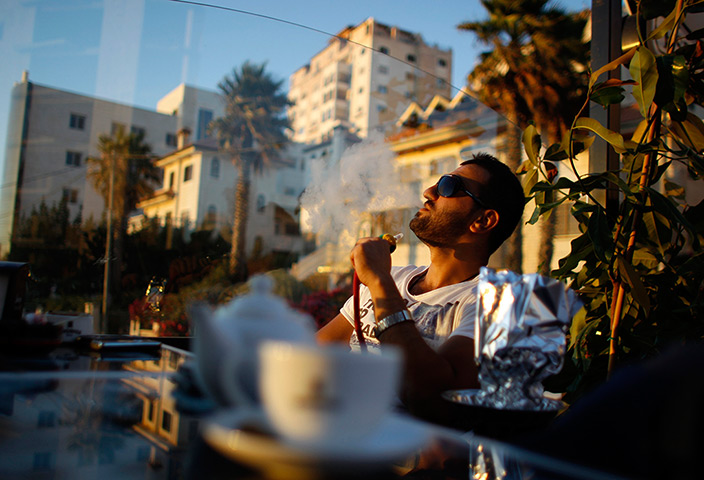 24 hours: Ramallah, West Bank: A Palestinian smokes a water pipe
