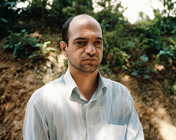 Rencontres Arles: A man stands staring into middle distance in woods