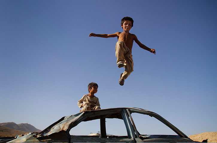 24 hours in pictures: An Afghan boy jumps down from a vehicle