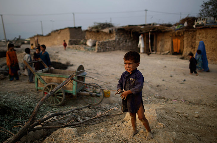 24 hours in pictures: An Afghan refugee boy stands in a slum
