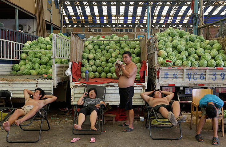 24 hours in pictures: Vendors rest in front of trucks stacked with watermelons 