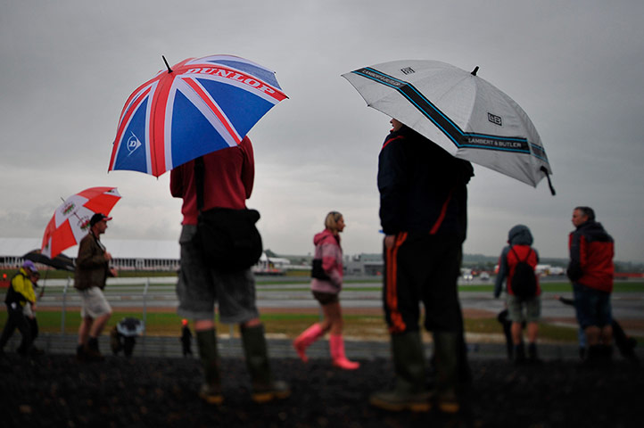 Rain: Spectators stand in the rain during the