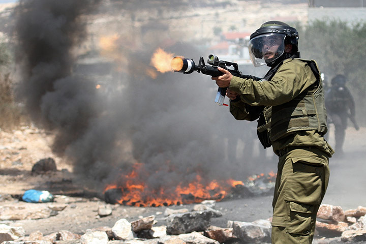 Picture desk live: An Israeli border policeman fires teargas