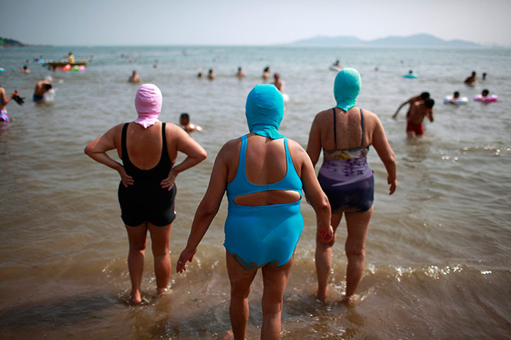 24 Hours: Women, wearing nylon masks, walk towards the sea in China